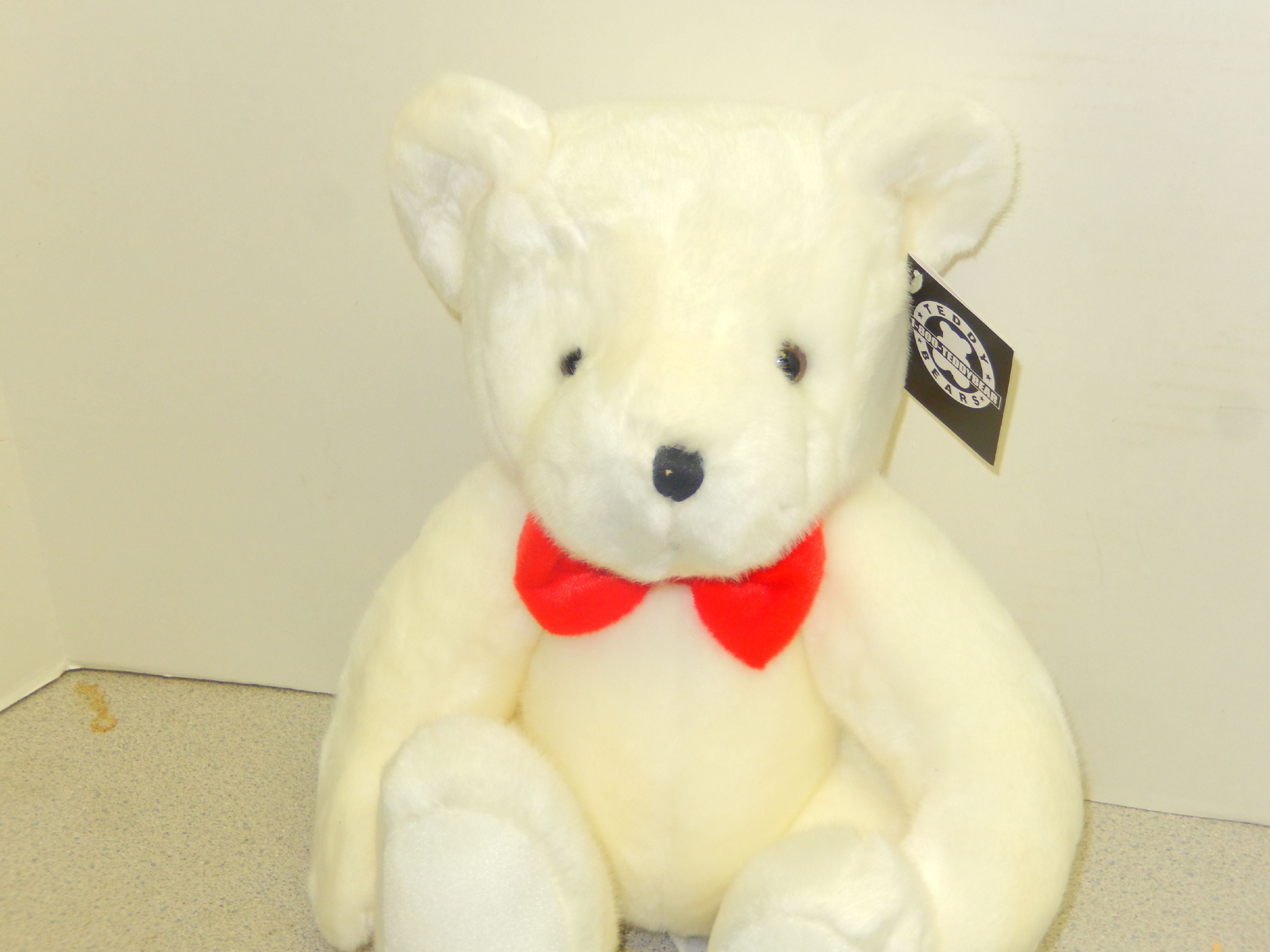 big white teddy bear with red bow