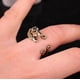 thumbnail image 1 of Ring med hund som kramar fingret tax svart guld silver, 1 of 2