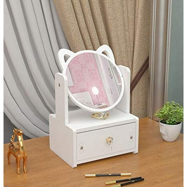 organizador de maquillaje cajas de exhibición de almacenamiento de cosméticos con espejo para baño, tocador, tocador y encimera. Vista frontal centrada de un organizador con espejo circular ajustable con orejas decorativas; base con cajón frontal y compartimento superior para anillos, horquillas y accesorios pequeños, situado sobre una encimera junto a una maceta; según especificaciones, fácil de ensamblar y a menudo se usa también para organizar joyería pequeña durante viajes.