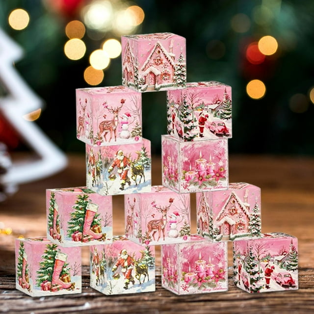 bolsa de navidad para regalos macarena bolsas de regalo de navidad papel de regalo navideño p 12b Paquete de 12 cajas de regalo de papel (7 x 7 x 7 cm) apiladas en forma de pirámide; cubos rosa con escenas navideñas impresas (casitas de jengibre, renos, Papá Noel y velas) sobre mesa de madera y luces festivas difuminadas al fondo, ideales para envolver pequeños obsequios o decorar la mesa navideña.