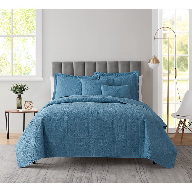 Clara Clark Home Quilt Set Bedspread in Blue Heaven, featuring an ultra-soft microfiber embossed grid weave design. This lightweight 5-piece bedding set includes a quilted comforter, 2 pillow shams, and 2 Euro shams, displayed on a twin-sized bed in a modern bedroom with a grey upholstered headboard and natural light streaming through a window.
