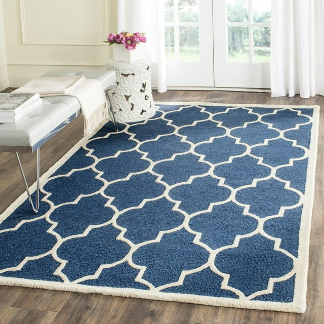 Safavieh Cambridge Kevin blue area rug featuring a white geometric trellis pattern on hardwood flooring.