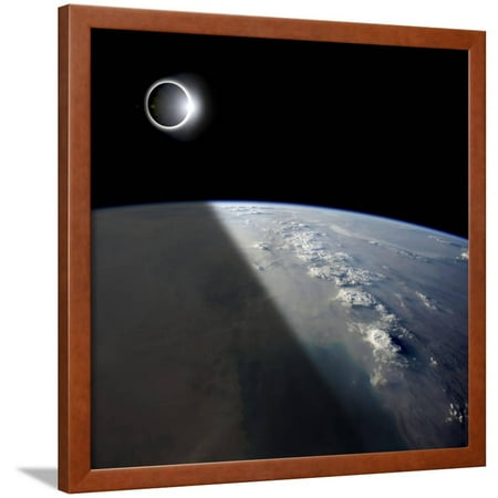 A Solar Eclipses Partially Shades the Earth Below Framed Print Wall Art By Stocktrek