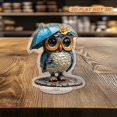thumbnail image 5 of Rotating acrylic ornament featuring a colorful glass owl with a rain hat and umbrella, wearing a cyan raincoat on a cobblestone road, 5 of 8