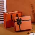 thumbnail image 2 of Caja de regalo de cartón naranja de 27 x 27 x 3 cm con cinta negra, 2 of 2