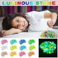thumbnail image 1 of 300 piedras luminosas • Guijarros luminosos multicolores para decoración de jardines, acuarios y piscinas • Piedras luminosas de 1,4x1,1 cm para relleno de pasarelas, paisajes y jarrones, 1 of 3