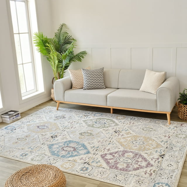 Rug Branch Nomad Vintage indoor area rug in beige and grey with boho geometric designs placed under a modern light gray sofa, styled for living room decor.