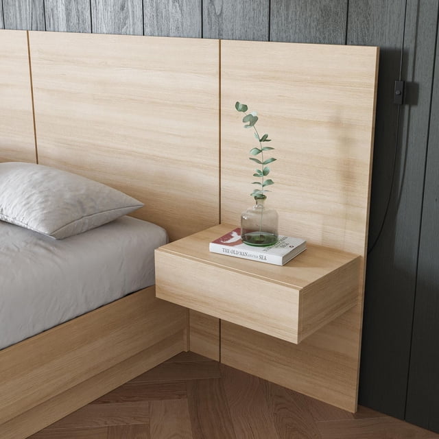 Nexera Milano floating nightstand extension panel in light wood mounted beside bed with book and glass vase on top.