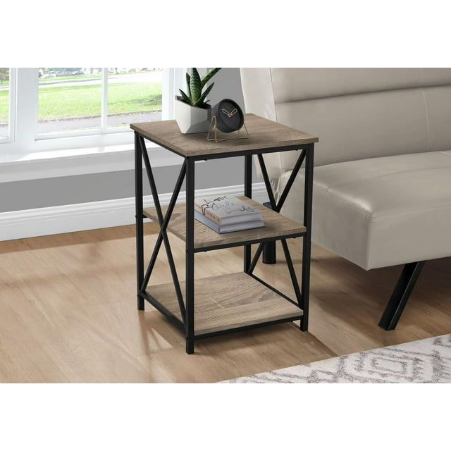 Monarch Specialties accent table with three tiers featuring a square dark taupe wood-look laminate tabletop and two storage shelves, supported by a slender black metal frame with X-shaped side accents, placed beside a beige sofa on a light wood floor near a window, ideal as a side table or nightstand in compact living spaces.
