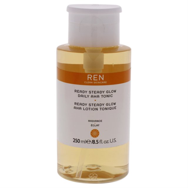 ready steady glow daily aha tonic de ren para mujeres - 8.45 oz toner. Botella frontal transparente con tapa blanca y líquido ámbar claro; etiqueta blanca y naranja con logo REN, texto del producto y leyenda 250 ml/8.5 fl oz; envase cilíndrico para cuidado facial.