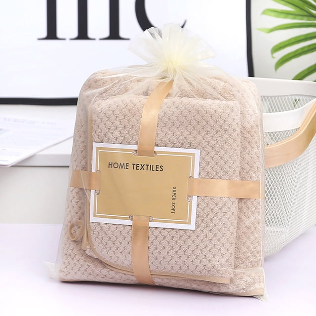 RKSTN Towels Coral Towel Bath Towel Set featuring a beige coral velvet bath towel and face towel, packaged in a transparent drawstring bag with a gold ribbon and label reading 'Home Textiles.' The set includes a 70 cm x 140 cm bath towel and a 35 cm x 75 cm face towel, designed for quick water absorption, softness, and durability. Suitable for use in bathrooms, gyms, beaches, and spas.