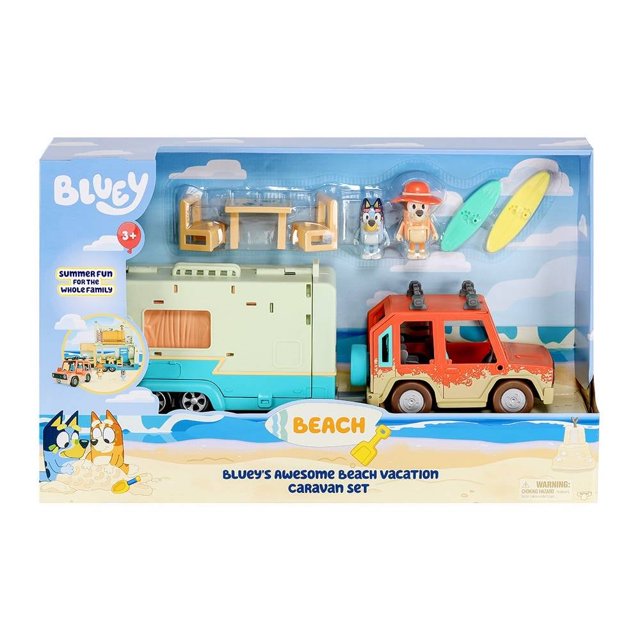 vehículo bandai bluey caravana vacaciones de playa juguete, vista frontal del set en caja con auto familiar rojo y caravana turquesa y crema; incluye figura de Papá, figura de Bluey, dos tablas de surf, mesa y sillas y hojas de calcomanías para decorar.