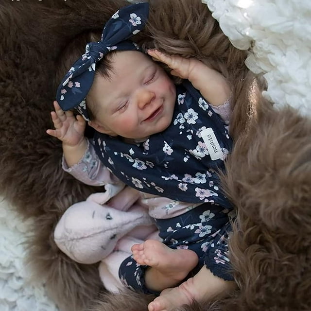 zlgkjk muñecas bebé reborn muñeca bebé recién nacida realista de 18" niña con cuerpo completo de silicona de vinilo suave; vista 3/4 lifestyle mostrando la muñeca dormida con ojos cerrados, cabello castaño tipo mohair con diadema floral, cara con rubor y cejas pintadas a mano y pestañas pegadas, extremidades articuladas de silicona con uñas detalladas, vestida con conjunto floral azul sobre ropa interior rosa y apoyada sobre manta peluda dentro de set de regalo; suele usarse como compañero de juego para niñas mayores de 3 años.