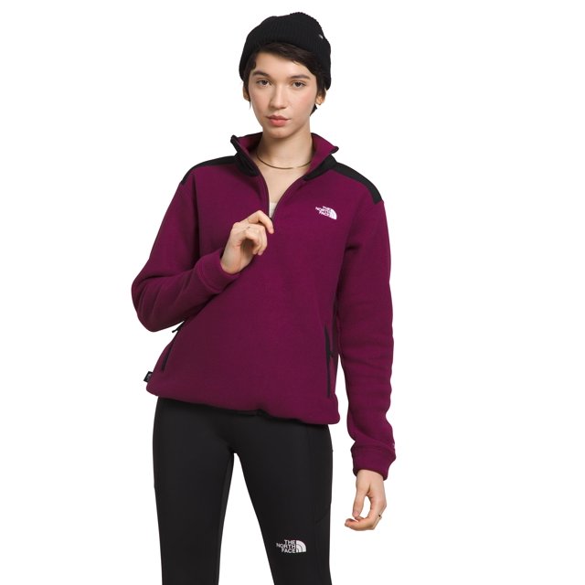 jersey the north face alpine polartec 200 para mujer boysenberry 1/4 zip de manga larga color boysenberry con paneles negros en hombros, logotipo blanco en el pecho, dobladillo ajustable y cierre parcial en el cuello; modelo de frente sobre fondo blanco. También suele usarse como capa intermedia para senderismo o uso urbano.