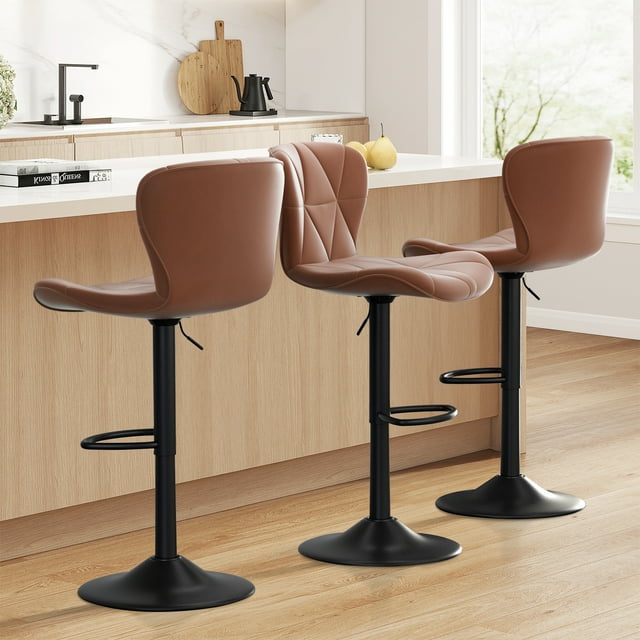 Hawsaiy Modern Bar Stools Set of 3, featuring adjustable faux leather upholstered swivel bar stools in brown. These stools have a 360° swivel, adjustable height (24.8”-33.46”), and ergonomic cushioned seats with backrests for comfort. The sturdy black pedestal base includes a footrest, and the stools are shown in a modern kitchen setting with a light wood island and white countertop.