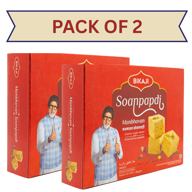 Bikaji Soan Papdi 500g, Pack Of 2, Indian sweets featuring two red boxes of traditional flaky confection. Each box highlights the Manbhavan Soanpapdi branding, showcasing pistachios and almonds garnishing, and cardamom-infused layers of crispy gram and wheat flour threads. Suitable for gifting or festive sharing.