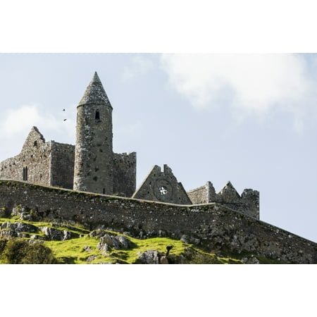 Ancient stone ruin with stone wall turret and church on rocky grassy hillside with blue sky and clouds Cashel County Tipperary Ireland Stretched Canvas - Michael Interisano  Design Pics (19 x