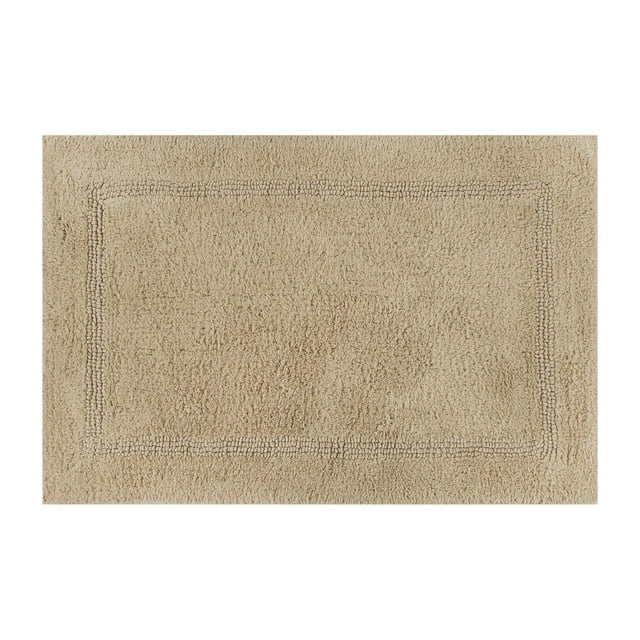 Cotton reversible bath rug in almond biscuit color with a rectangular textured border, sized 17 by 24 inches.