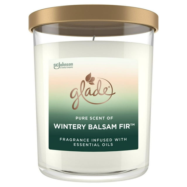 Large Glade candle in clear glass jar with gold lid, labeled Wintry Balsam Fir scent infused with essential oils.
