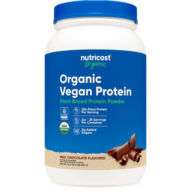 suplemento de proteína nutricost orgánico vegano sabor chocolate 907g envase frontal centrado: bote blanco con etiqueta azul y tapa azul que muestra proteína vegana orgánica, 20 g por porción, 25 porciones (907 g) y 0 g azúcares añadidos; diseño con trozos de chocolate en la base; a menudo usado como batido postentreno o mezclado en avena para aumentar proteína.