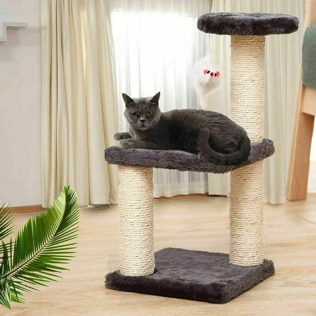 Cat Bed for Small Felines, Soft Cat Hammock with Ultra-Durable Scratching Posts Perfect for Indoor Cats, Portable Cat Tower. The image shows a compact cat tree featuring two sisal-wrapped scratching posts and three plush platforms, including a hammock-style middle tier. A grey cat is resting on the middle platform, and a dangling toy is attached to the top tier. The setup is positioned in a bright indoor room with wooden flooring and light curtains in the background.