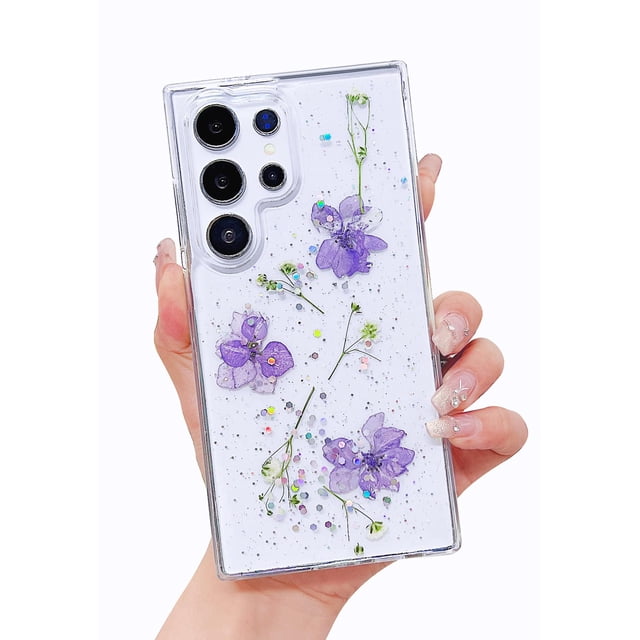 funda de teléfono lewrtser compatible con samsung galaxy s24 ultra funda transparente con flores reales prensadas, vista posterior centrada; carcasa trasera de policarbonato rígido y marco TPU flexible, flores moradas y tallos verdes visibles, microbrillos incrustados, recortes precisos para cámara y botones, bisel elevado de cámara 0.110 in y bordes de pantalla 0.039 in, hecha a mano (patrón puede variar). Adecuada para uso diario y para quienes buscan una funda ligera y decorativa.