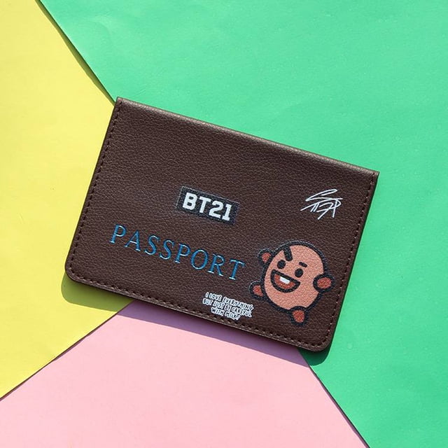 bts bt21-funda de piel para pasaporte funda de pasaporte 10 x 14.3 cm en cuero de poliuretano color Shooky, vista frontal centrada con logo BT21, texto PASSPORT en azul y personaje Shooky impreso sobre fondo geométrico. A menudo se usa también como tarjetero de viaje compacto.