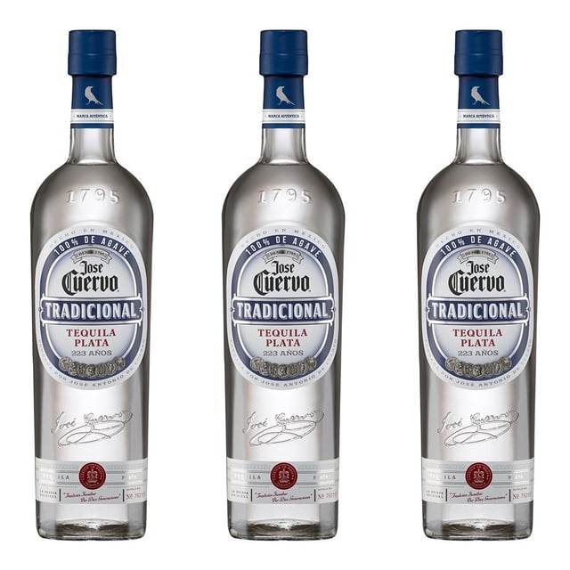 paquete 3 botellas tequila jose cuervo tradicional plata 950 ml tres botellas alineadas frontalmente, botellas altas y cilíndricas de vidrio cristalino con etiqueta ovalada blanca y azul que dice 'Jose Cuervo Tradicional Tequila Plata', tapón azul y reflejos de luz en el líquido transparente sobre fondo blanco minimalista; venta solo para mayores de 18 años.