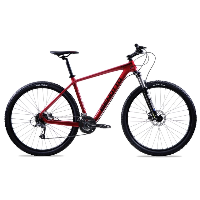 bicicleta benotto montaña kutang r29 carbón fiber 3x8 rojo/negro talla mm. Vista lateral de perfil derecho con cuadro de carbón rojo y logotipo Benotto en negro; horquilla SUNTOUR aluminio, manubrio y potencia de aluminio, sillín ergonómico y poste de asiento de aluminio negro. Ruedas 29 pulgadas con llantas Kenda 29x2.2 y rines de aluminio doble pared; transmisión 3x8 con platos Shimano 42x34x24 y cassette 8p 11-32; frenos disco TEKTRO hidráulicos. Su tamaño compacto la hace adecuada para transporte en portabicicletas.