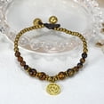 thumbnail image 2 of AeraVida Mystical Aum or Om Brown Tiger's Eye and Brass Beads Jingle Bell Bracelet for Female Anniversary, 2 of 6