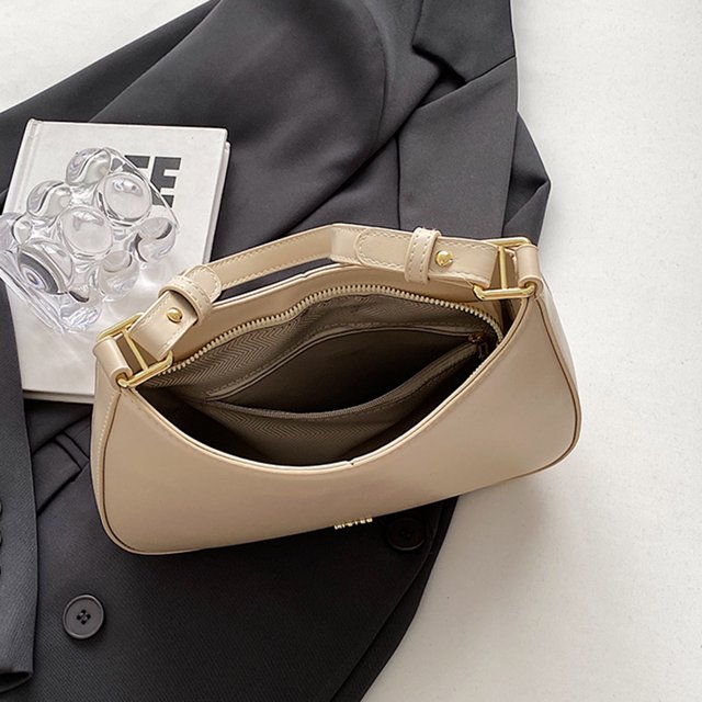 bolso bandolera de cuero pu a la moda, bolsos diarios vintage de color sólido para mujer (beige) Bolso beige de PU visto desde arriba en 3/4 abierto, silueta media luna con correa corta y herrajes dorados, cremallera superior y bolsillo interior con cremallera; tamaño aproximado 25x16x6 cm, colocado sobre saco oscuro; a menudo usado como bolso diario compacto para salir.