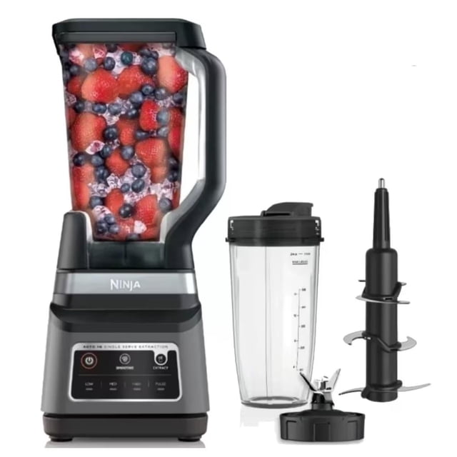 licuadora ninja bn750 profesional.. Licuadora profesional negra 2 en 1 con jarra grande llena de frutas, base frontal con panel de botones y dos programas Auto-iQ, logo Ninja visible, vaso Nutri transparente con tapa para llevar y accesorio extractor de nutrientes desmontable; vista frontal sobre fondo blanco; el vaso Nutri suele usarse como recipiente portátil para llevar batidos.