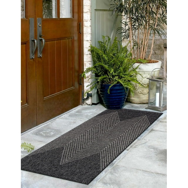 ECARPET Raven contemporary runner rug with dark gray color and chevron pattern, displayed at an entranceway with wooden double doors, potted plants, and lantern.