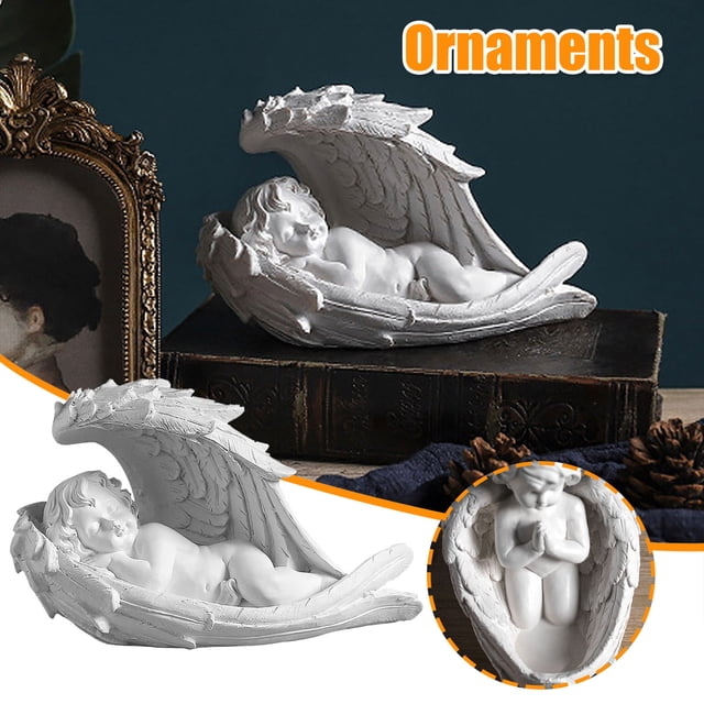 fiudx angelito decorativo, escultura artesanal de resina, adorno de estilo europeo, para escaparates, decoración versátil para el hogar, perfecto para regalar, 1 ángel de almacenamiento, tamaño 13 x: vista 3/4 frontal de un ángel reclinado dentro de dos alas curvas que forman una cuna; detalle de textura tallada en resina y plumas, rostro infantil dormido, colocado sobre un libro en un fondo oscuro; color declarado multicolor; también usado como adorno en vitrinas o repisas.