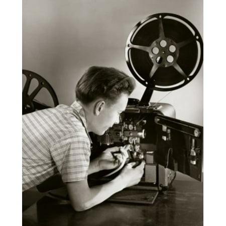 Side profile of a boy loading a film reel on a projector Stretched Canvas -  (18 x
