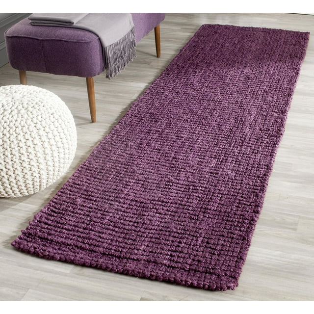 Safavieh Natural Fiber Levi Braided Area Rug in deep purple displayed on a light wood floor next to a matching purple bench and white knitted pouf.