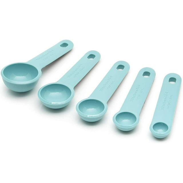 cucharas medidoras kitchenaid juego de 5 aqua sky juego de cinco piezas en aqua sky con mangos planos y orificios para colgar, disposición diagonal mostrando 15 ml, 7.5 ml, 5 ml, 2.5 ml y 1.25 ml grabados en los mangos; aptas para medir ingredientes húmedos y secos en repostería y también usadas con frecuencia para dosificar especias al preparar mezclas caseras.