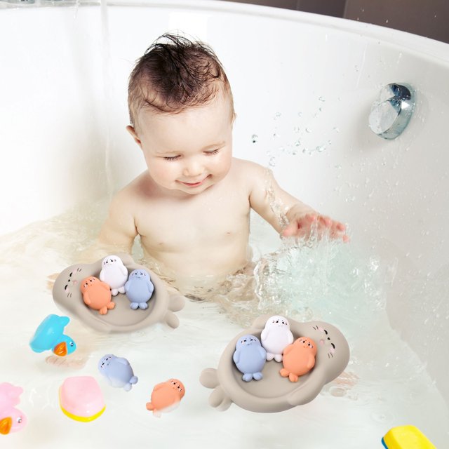 adorable set de juguetes de baño con forma de animales flotantes | goma suave; vista frontal de bañera con dos platos grises flotantes que sostienen cuatro figuras pequeñas multicolor (azul, naranja, blanco, lila) y tres juguetes pequeños adicionales en el agua; bordes redondeados y superficie lisa, apto para mayores de 18 meses; adecuado también para juegos sensoriales en recipientes pequeños.