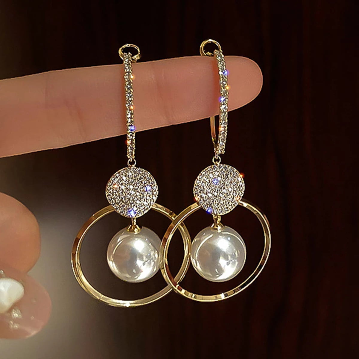 Earrings with gold on silver pendants and facet cut glass stones in gilded frame and freshwater pearl