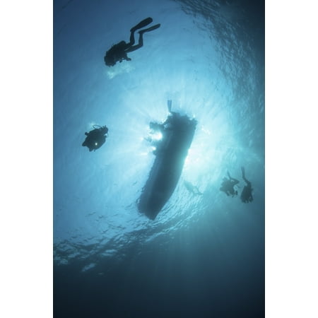 Scuba divers descend from their dive boat in the tropical Pacific Ocean Poster