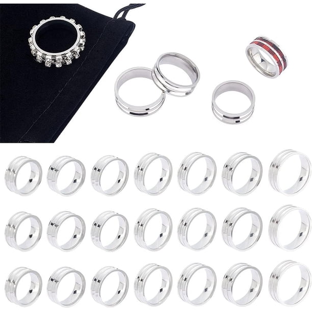 21 anillos de dedo de acero inoxidable con ranuras para incrustaciones, redondos, vacíos y con bolsitas de terciopelo, en 7 tamaños.