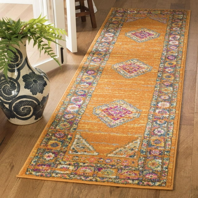 SAFAVIEH Madison Emmet traditional area rug in orange with colorful diamond and floral border patterns displayed on hardwood floor beside a ceramic vase holding green fern leaves.