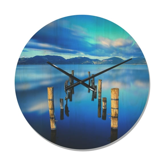 Designart 'Wooden Pier Remains in Blue Mountain Sea ' Modern Wood Wall Clock