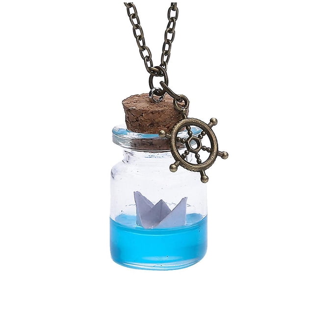 Collar de botella a la deriva con barco de papel de agua de mar y botella de vidrio