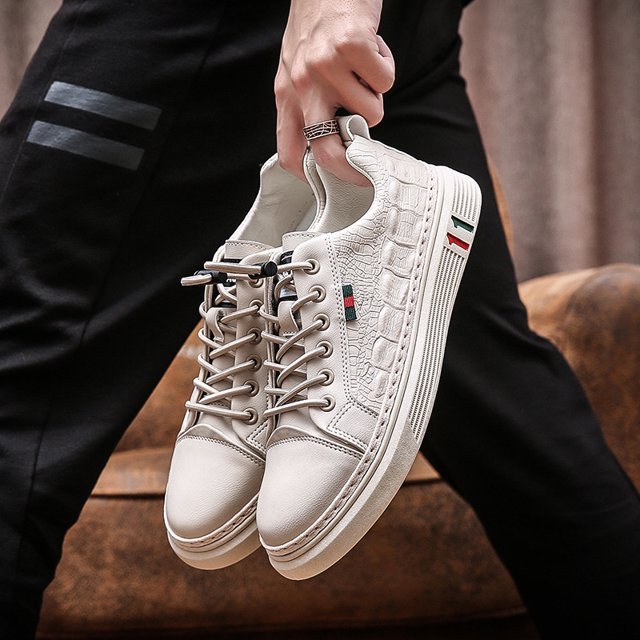 zapatos de estudiante de primavera para hombre zapatillas informales con estampado de cocodrilo transpirables y a la moda para hombre par beige talla 43, vista 3/4 frontal sostenidos por la mano; sneaker de corte bajo con puntera redondeada, cordones con tope elástico, laterales en PU con textura de cocodrilo, suela gruesa estriada con franjas verdes y rojas, interior acolchado, adecuado para uso diario y caminatas urbanas.