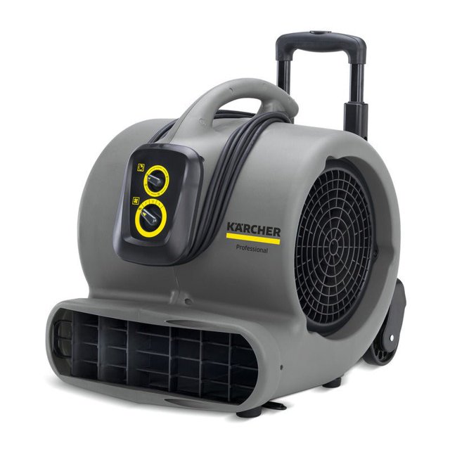 ab 84 (sustituto) secador móvil Karcher, vista frontal 3/4 con carcasa plástica gris aerodinámica, manija retráctil vertical y cable enrollado; panel frontal con dos mandos amarillos para 3 velocidades, ventilador radial con rejilla lateral, clip para alfombras integrado y ruedas grandes para transporte; también apto como soplador temporal para secado localizado en obras pequeñas.