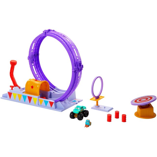 set de vehículos de juguete mattel cars on the road loop playset multicolor. Vista frontal centrada de la pista con bucle púrpura, lanzador con palanca roja y plataforma con banderines; objetivo giratorio blanco y rojo sobre base amarilla, tres barriles rojos, camioneta monstruo verde Ivy y figura Circus Stunt Performer sobre fondo blanco. También suele usarse para juegos de exhibición y acrobacias imaginarias.