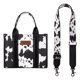 thumbnail image 4 of Bolso Wrangler con estampado de vaca para mujer, negro, con correa de guitarra, 4 of 6