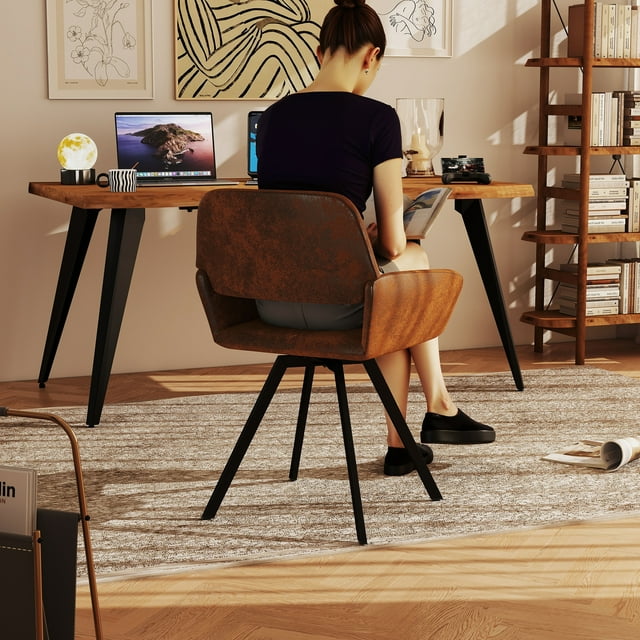 Home office setup featuring Homy Casa writing desk with natural live edge wood top and black angled legs, woman seated reading at the desk surrounded by bookshelves and decor.
