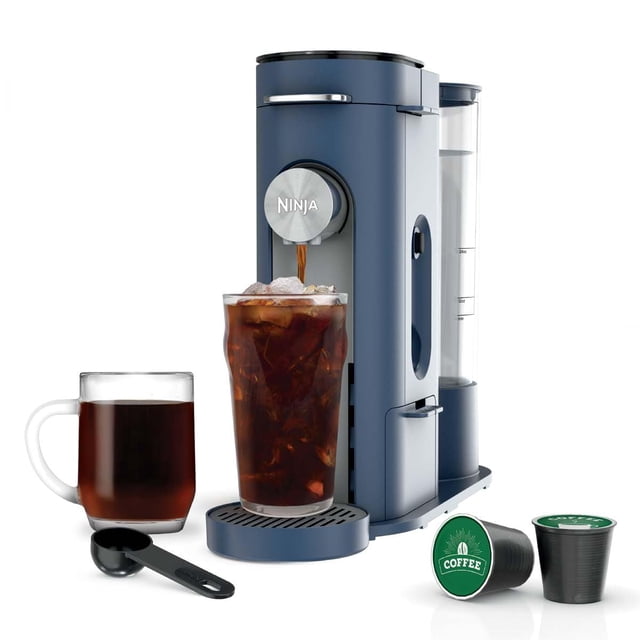 cafetera ninja pods & grounds de una sola porción pb041nv navy Cafetera de una sola porción azul marino, vista frontal inclinada con depósito de agua transparente de 56 oz, boquilla con logo Ninja y bandeja de goteo circular; muestra taza de viaje con café helado, taza de cerámica con café caliente, cucharilla dosificadora y cápsulas compatibles K-Cup. Diseño compacto con cajón de almacenamiento para la cesta de preparación; también adecuada para preparar bebidas frías para llevar.